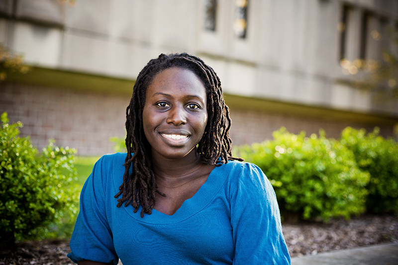 Young woman student in a blue dress smiling at the camera
