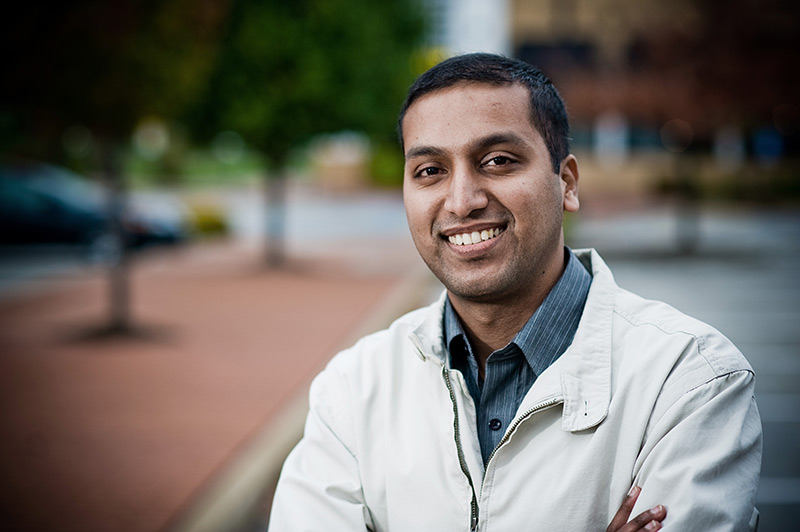 Young south asian man outdoors smiles at the camera