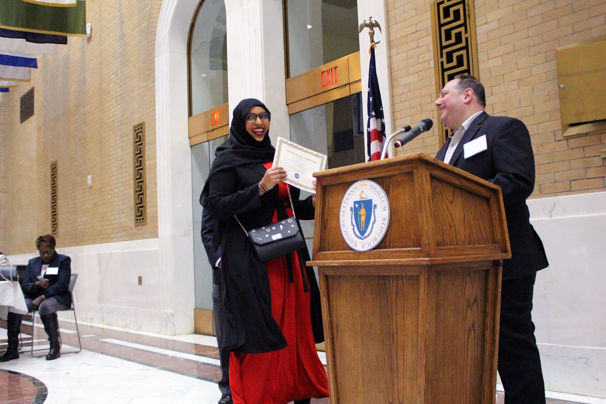 Female student in hijab receiving diploma at a convocation ceremony