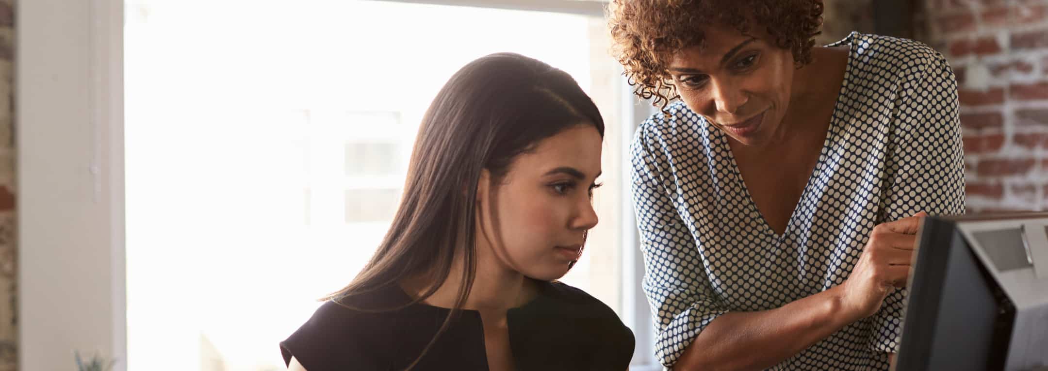 Teacher helping student at desk