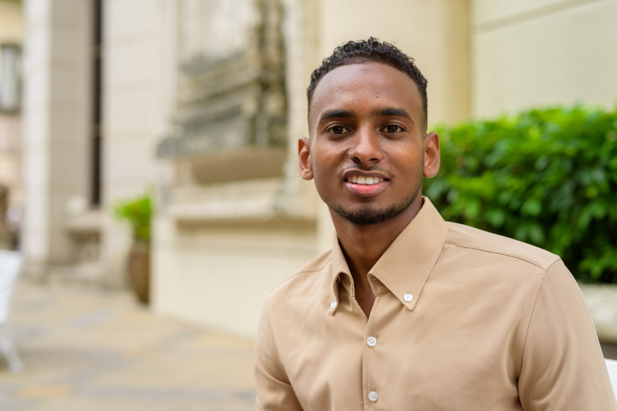 Portrait of handsome black young African student wearing casual clothes outdoors in city