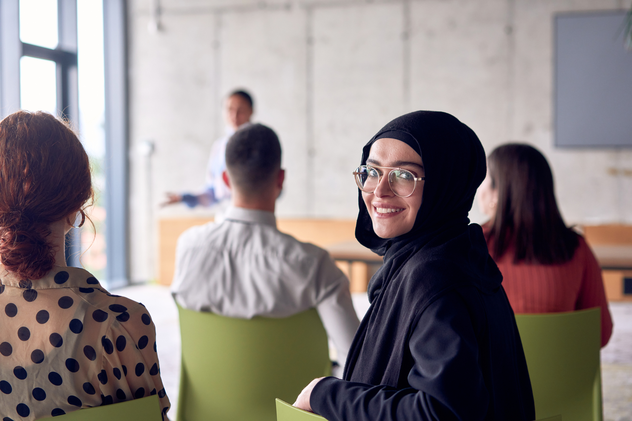 A young hijab woman entrepreneur is attentively listening to a presentation by her colleagues, reflecting the spirit of creativity, collaboration, problem-solving, entrepreneurship, and empowerment A young hijab woman entrepreneur is attentively listening to a presentation by her colleagues, reflecting the spirit of creativity, collaboration, problem-solving, entrepreneurship, and empowerment