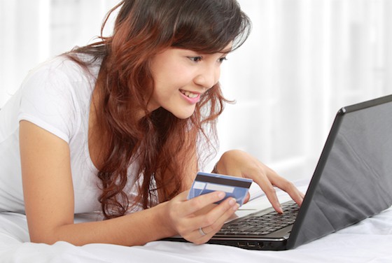 Woman at laptop with credit card in hand