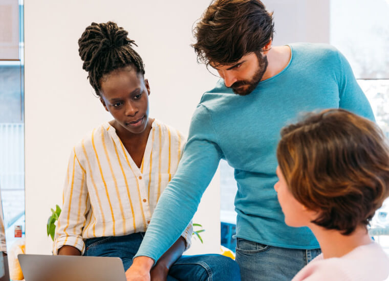 group of three people discussing an assessment report.