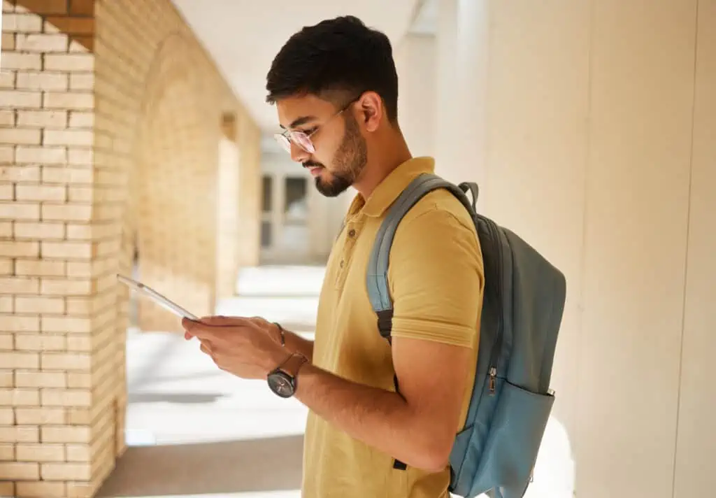 student looking at tablet in the hallway