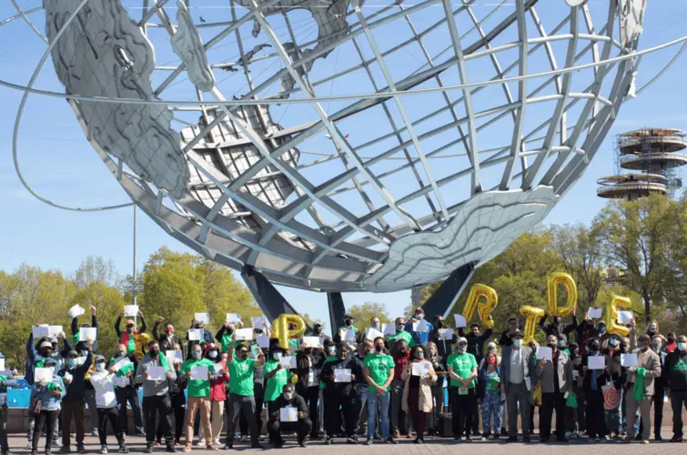 Collective action: Image shows many people beneath a sculture of a globe.