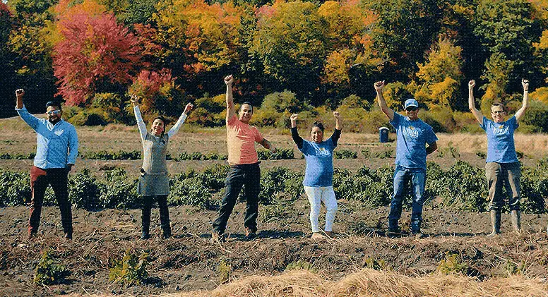 Students in field raising their arms