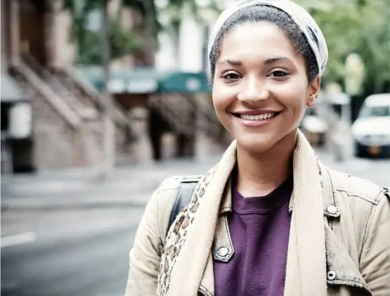 Young female college Student standing and smiling on the street