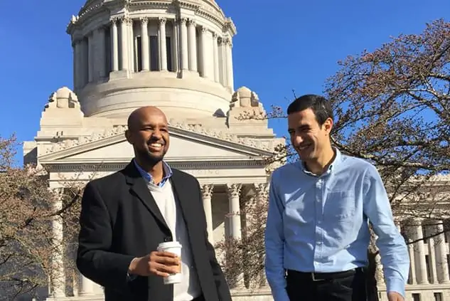 Professional men talking in front of a U.S. government building
